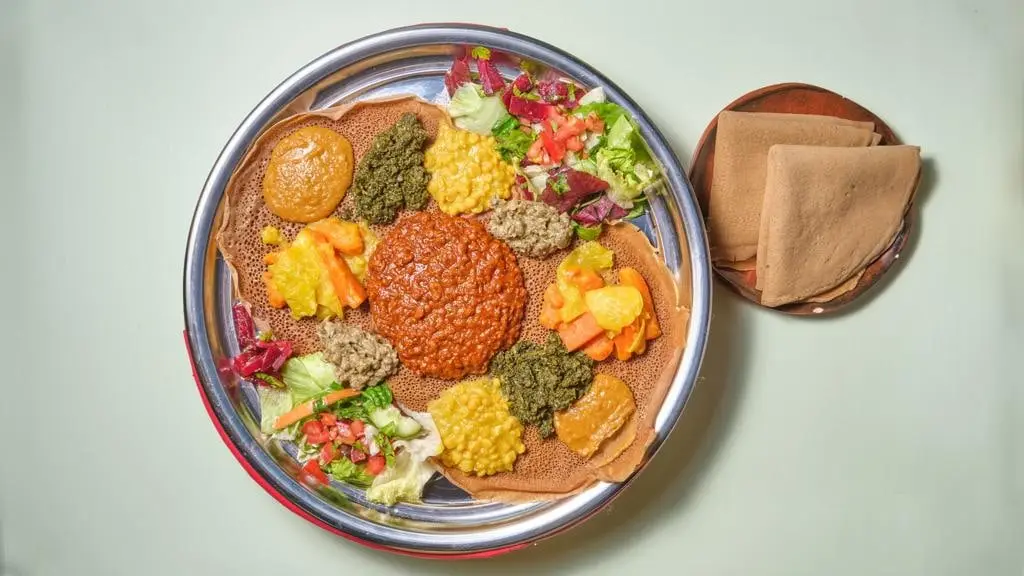 Beyaynetu von oben: mehrere Wat-Gerichte auf frischer Injera